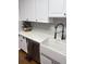 Kitchen detail showcasing quartz countertops, white cabinets, farmhouse sink, and stylish black faucet at 1606 Waterside Blvd, Moncks Corner, SC 29461