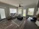 Cozy living room with hardwood floors, gray sofa and ottoman, ceiling fan, and flat screen TV at 1606 Waterside Blvd, Moncks Corner, SC 29461