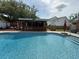 Refreshing pool surrounded by deck, a covered bar area, and views of the home's manicured yard at 1606 Waterside Blvd, Moncks Corner, SC 29461