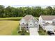 Aerial view of a charming gray two-story home with a pond in the background and surrounded by lush green trees at 167 Cherry Grove Dr, Summerville, SC 29483