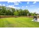 Spacious backyard featuring a lush lawn, privacy fence, and a grill on a stone patio at 167 Cherry Grove Dr, Summerville, SC 29483