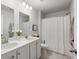 Bright bathroom with double vanity, white cabinets, tile floors and shower with white curtain at 167 Cherry Grove Dr, Summerville, SC 29483