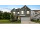 Charming two-story home with gray siding, white trim, a well-manicured lawn and an attached two-car garage at dusk at 167 Cherry Grove Dr, Summerville, SC 29483