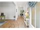 Inviting foyer with light wood floors, white walls, decorative mirror and flowers, creating a warm and welcoming entrance at 167 Cherry Grove Dr, Summerville, SC 29483