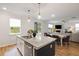 Modern kitchen with white cabinets, granite countertops, stainless steel appliances, and a center island, opening to the living and dining areas at 167 Cherry Grove Dr, Summerville, SC 29483
