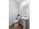 Clean powder room with a pedestal sink, decorative mirror, wood look flooring, and neutral paint at 167 Cherry Grove Dr, Summerville, SC 29483