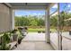 A view from the screened in back porch to a manicured lawn with a grill and outdoor seating area at 167 Cherry Grove Dr, Summerville, SC 29483