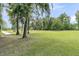 Spacious backyard with mature trees, a wooden walkway, and ample green space for outdoor enjoyment at 1711 Indigo Island Dr, Hanahan, SC 29410