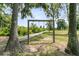 Backyard swing set and wood walkway nestled among mature trees in this private outdoor space at 1711 Indigo Island Dr, Hanahan, SC 29410
