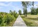 A wood walkway leads through a tree-filled backyard, blending nature with outdoor adventure at 1711 Indigo Island Dr, Hanahan, SC 29410