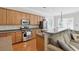 Open-concept kitchen with stainless steel appliances, wood cabinets, bar top seating and dining area at 1787 Tennyson Row # 9, Mount Pleasant, SC 29466