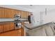Open-concept kitchen with stainless steel appliances, wood cabinets, and bar top seating at 1787 Tennyson Row # 9, Mount Pleasant, SC 29466
