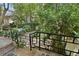 An exterior view of the backyard featuring brick steps, black metal railings, and ample greenery at 19 Ashley Ave, Charleston, SC 29401