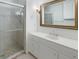 Bathroom features a glass-enclosed shower, vanity with granite countertop, and decorative mirror at 19 Ashley Ave, Charleston, SC 29401
