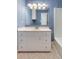 Bathroom features blue textured wallpaper, white vanity, tile floors, and a large mirror at 19 Ashley Ave, Charleston, SC 29401