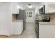 Galley kitchen with white cabinets, stainless steel appliances, and tiled countertops at 19 Ashley Ave, Charleston, SC 29401