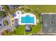Aerial view of a sparkling pool with lounge chairs and a clubhouse, surrounded by lush greenery and tennis courts at 203 Yeamans Way, Summerville, SC 29483