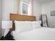 Well-lit bedroom with a white bed, a woven headboard, and a large window, offering a serene and relaxing atmosphere at 2128 Golfview Dr, Charleston, SC 29412