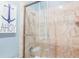 Walk-in shower with glass door, decorative tiling, shower head and faucet, along with nautical artwork at 25 Ocean Point Dr, Isle of Palms, SC 29451