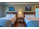 Bedroom with dual beds, patterned quilts, and paintings displayed above each bed at 25 Ocean Point Dr, Isle of Palms, SC 29451