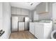 Modern laundry room with gray cabinets, stainless steel appliances, and wood-look vinyl flooring at 2864 Wofford Rd, Charleston, SC 29414