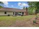 Wide shot of the backyard with a patio, chimney, and green lawn and lush surrounding trees at 300 Hamlet Rd, Summerville, SC 29485