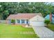 Charming one-story home with a manicured lawn, bright blue accents, and inviting front porch seating at 300 Hamlet Rd, Summerville, SC 29485