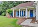 Charming front porch featuring comfortable seating, blue accents, a well-manicured lawn, and beautiful landscaping at 300 Hamlet Rd, Summerville, SC 29485