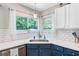 Kitchen sink beneath a window with white cabinets and backsplash with blue-gray cabinets at 300 Hamlet Rd, Summerville, SC 29485