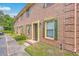Charming brick townhome with green shutters, a walkway, and partial view of a parking area at 302 Springview Ln # 10, Summerville, SC 29485