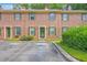 External view of brick townhome with green shutters and lush shrubbery, complemented by a parking space in front at 302 Springview Ln # 10, Summerville, SC 29485