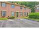 Exterior shot of a well-maintained brick townhome with green shutters, parking spaces, and a landscaped front yard at 302 Springview Ln # 10, Summerville, SC 29485