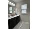 Bright bathroom with double sinks, dark cabinets, modern vanity, and large mirror and a window at 315 Grouse Park, Charleston, SC 29414