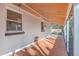 Covered back porch featuring a woven hanging light fixture, wood-look tile flooring and white columns at 32 Briarcliff Dr, Charleston, SC 29407