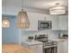 Kitchen area featuring stainless steel appliances, white cabinets, and modern light fixtures at 32 Briarcliff Dr, Charleston, SC 29407