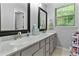 Bathroom featuring double sinks with gray cabinets, framed mirrors, and a window with natural light at 332 Damascus Dr, Summerville, SC 29483