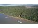 Aerial view of a wooded riverfront property featuring a private dock at 3360 Baldwin Ln, Green Pond, SC 29446