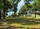 Expansive green backyard with large trees and water views, offering privacy and space at 3360 Baldwin Ln, Green Pond, SC 29446