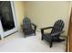 View of patio with two black Adirondack chairs and a sliding glass door at 339 Sea Cloud Cir, Edisto Island, SC 29438