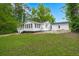 Exterior view of a charming white house with a lush green lawn and separate structure at 358 Highway 78, Ridgeville, SC 29472