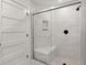 Glass-enclosed shower featuring marble-style tiling, a built-in seat, and convenient toiletry niches at 358 Highway 78, Ridgeville, SC 29472