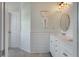 Bright bathroom with white wainscoting and shiplap, a double vanity, and a decorative mirror at 3656 Spindrift Dr, Mount Pleasant, SC 29466