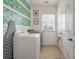 Laundry room featuring a patterned accent wall, washer and dryer, and tile floors at 3656 Spindrift Dr, Mount Pleasant, SC 29466