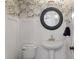 Stylish powder room features decorative wallpaper, a round mirror, and modern fixtures at 3656 Spindrift Dr, Mount Pleasant, SC 29466