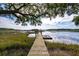 Scenic view down a private wooden dock that has a bench and floating platform on calm, reflective water at 3948 Gift Blvd, Johns Island, SC 29455
