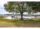 Waterside landscape view with mature trees, marsh grass, and dock with built-in bench at 3948 Gift Blvd, Johns Island, SC 29455