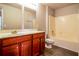 Bathroom featuring wood cabinets, large mirror, and combined shower and tub with tile and shower head at 4021 Sanderson Ln, Summerville, SC 29483