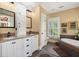 This bathroom features granite countertops, white cabinets, and a tub with beautiful surrounding tile at 423 Lake Moultrie Dr, Bonneau, SC 29431