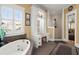 Bright bathroom featuring a soaking tub and large window allowing natural light, paired with a walk-in shower at 423 Lake Moultrie Dr, Bonneau, SC 29431