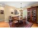 Elegant dining room with a traditional chandelier, hardwood floors, and plenty of natural light at 423 Lake Moultrie Dr, Bonneau, SC 29431